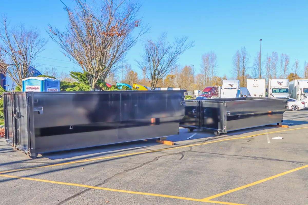 Professional dumpster rental service with roll-off container on residential driveway in Rapid Valley